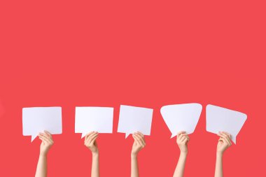 Kırmızı arkaplanda konuşma baloncukları olan kadın eller