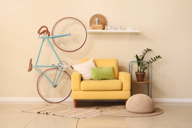Koltuk, raf ve bisiklet odada bej duvarın yanında.