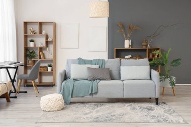 Oturma odasının içinde kanepe, sentezleyici ve raf üniteleri var.