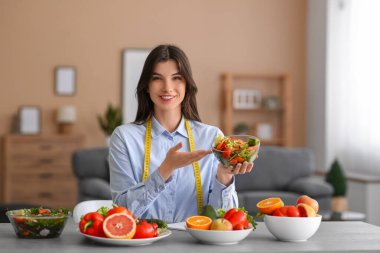 Ofisinde sebze salatası olan güzel bir beslenme uzmanı.