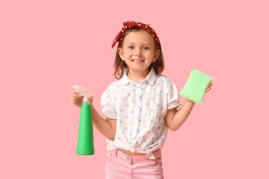 Pembe arka planda bir şişe deterjanı ve süngeri olan tatlı küçük mutlu kız.