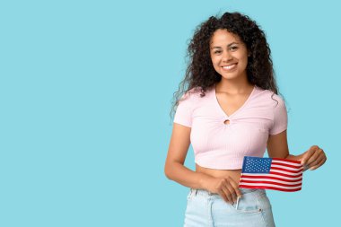 Mavi arka planda Amerikan bayrağı olan mutlu Afro-Amerikan kadın.