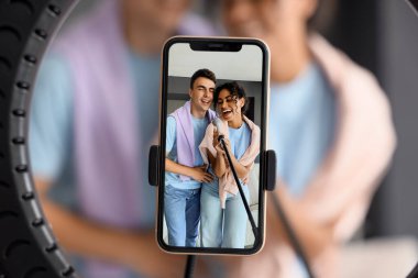 Evde cep telefonu ekranında mikrofon kayıt videosu olan genç blogcular, yakın plan