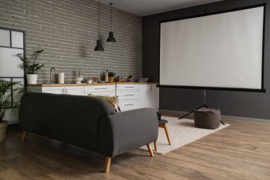 Mutfağın içinde tezgah, kanepe ve projektör ekran var.