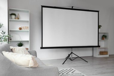 Kanepe, raf üniteleri ve projektör ekranlı aydınlatma odasının içi