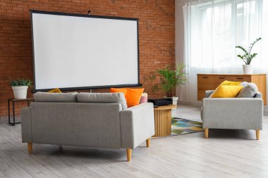 Kanepeler, tablo ve projektör ekranlı odanın içi