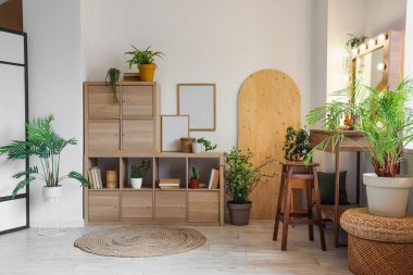 Masası, raf ünitesi ve bitkileri olan makyaj odasının içi.