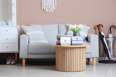 Koridorun içinde kanepe, masa ve şemsiyeler var.