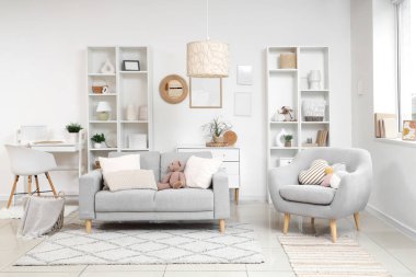 Yumuşak kanepesi ve raf ünitesi olan şık bir oturma odası.