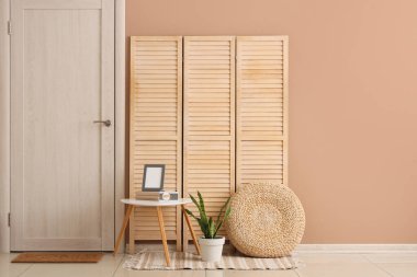 Kapısı, kapısı ve kahve masası bej duvarın yanında olan şık bir koridor.