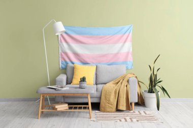 Travesti bayrağı, kanepesi ve yumuşak bankı olan oturma odasının içinde.