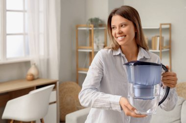 Su filtresi sürahisi olan genç bir kadın.