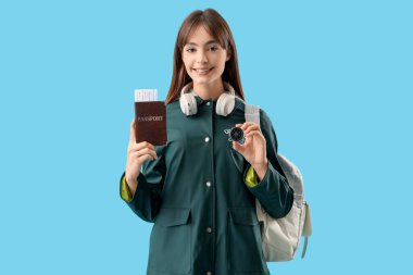 Mavi arka planda pusula ve pasaportlu kadın turist.