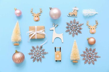 Açık mavi arkaplanda hediye ve Noel sembolleri