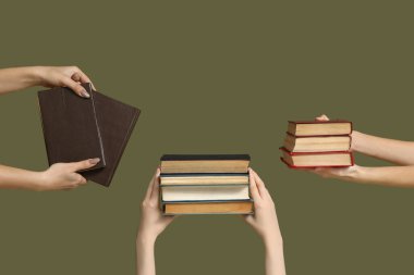 Renk arkaplanı üzerine birçok kitap tutan eller