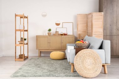 Oturma odasının içinde klozet, raf ünitesi ve dizüstü bilgisayar koltukta.