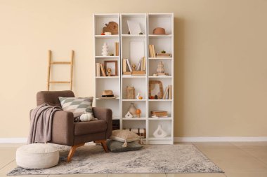 Koltuk, raf ve sonbahar dekoru oturma odasının içinde.