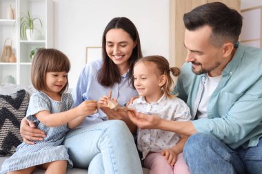 Mutlu bir aile evdeki kanepede tahta uçakla oynuyor.