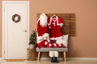 Interior of hall with Santa costumes, bench and Christmas tree clipart