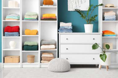 Çekmeceleri ve şık kadın kıyafetleriyle dolu bir dolap.