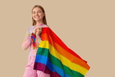 Bej arka planda LGBT bayrağı taşıyan gülümseyen genç kadın