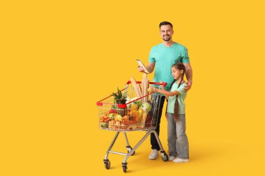 Genç, mutlu bir baba ve kızı ellerinde sarı arka planda bir defter tutuyorlar.