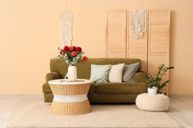 Kahve masasındaki vazoda Dahlia çiçekleri ve oturma odasının içindeki rahat kanepe.