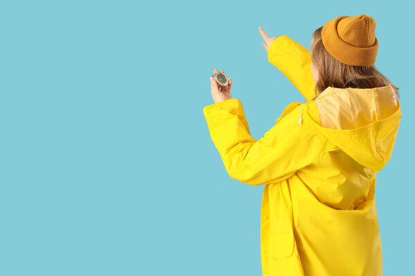 Молодая морячка с компасом, указывающая на что-то на синем фоне, вид сзади. Женщина в мужской профессии