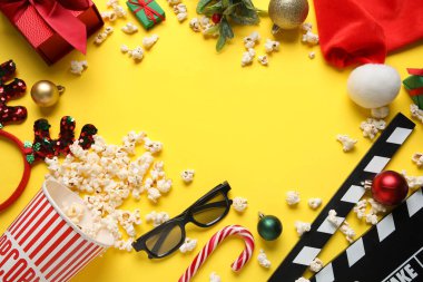 Patlamış mısırdan yapılmış çerçeve, film alkışı, üç boyutlu gözlükler, hediyeler ve sarı arka planda süslemeler. Noel filmi