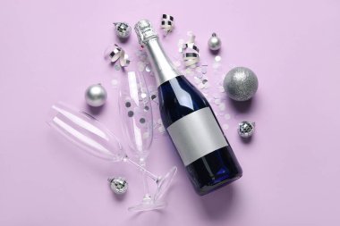 Bir şişe şampanya ve leylak arkaplanlı konfeti. Yeni yıl kutlaması