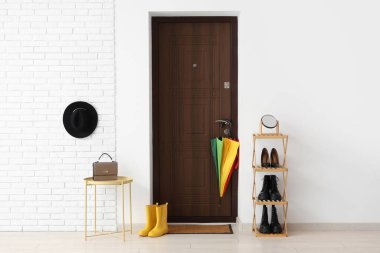 Paspası, şemsiyesi ve ayakkabı standı olan modern koridorun içi.