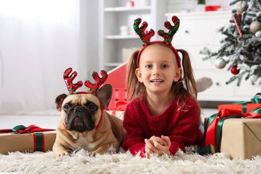 Evde Fransız bulldog 'u ve Noel hediyeleriyle sevimli küçük bir kız.