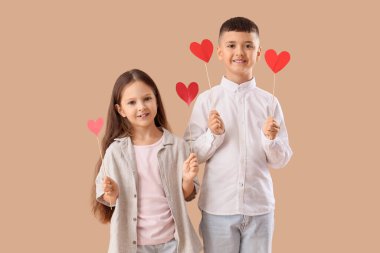 Bej arka planda kalpleri olan sevimli küçük çocuklar. Sevgililer Günü kutlaması