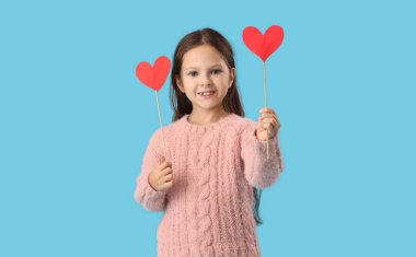 Mavi arka planda kalpleri olan sevimli küçük bir kız. Sevgililer Günü kutlaması