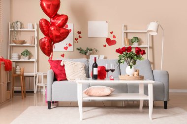 Sevgililer Günü için dekore edilmiş oturma odasının içi kanepe, masa ve balonlarla dolu.