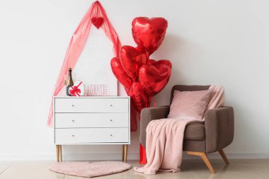 Oturma odasının içi Sevgililer Günü için koltuk, çekmece ve balonlarla dekore edilmiş.