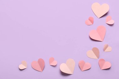 Leylak arka planında farklı kağıt kalpler olan kompozisyon. Sevgililer Günü kutlaması