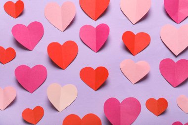 Leylak arka planında farklı kağıt kalpler olan kompozisyon. Sevgililer Günü kutlaması