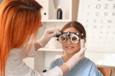 Kadın göz doktoru, klinikte küçük bir kızı yargılıyor, yakın plan.