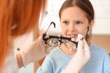 Kadın göz doktoru, klinikte küçük bir kızı yargılıyor, yakın plan.