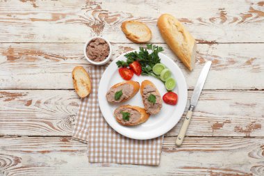 Lezzetli börek, domates, maydanoz ve hafif ahşap zemin üzerinde soğan halkaları.