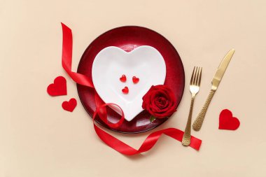 Bej arkaplanda ipek kurdele, gül ve kağıt kalplerle Sevgililer Günü için masa ayarı