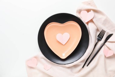 Beyaz arka planda kağıt kalpler ve peçeteyle Sevgililer Günü için masa ayarı