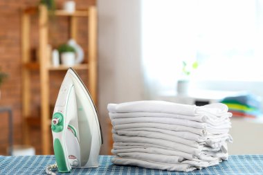 Banyo güvertesinde beyaz giysi yığını olan demir.