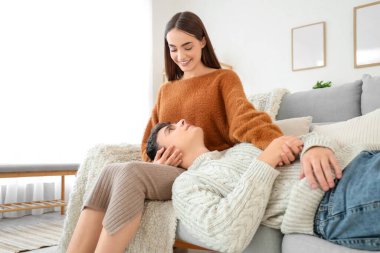 Sevgi dolu genç bir çift evdeki kanepede yatıyor.