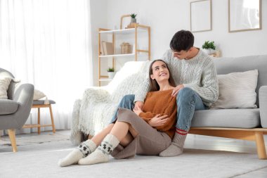 Kareli elbiseli, mutlu ve sevgi dolu bir çift evde oturuyor.