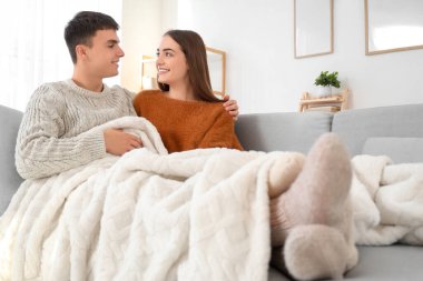 Evdeki kanepede oturan ekoseli mutlu çifti seviyorum.