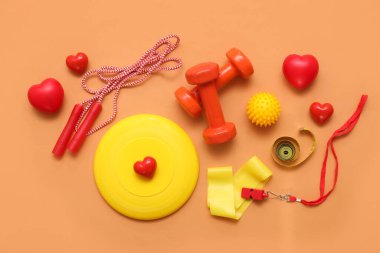 Farklı spor ekipmanlarıyla kompozisyon ve arka planda kırmızı kalpler. Sevgililer Günü kutlaması