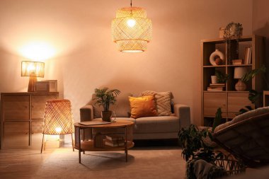 Yumuşak kanepe, sehpa ve geceleri oturma odasının içinde parlayan lambalar.