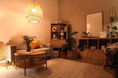 Yumuşak kanepe, sehpa ve geceleri oturma odasının içinde parlayan lambalar.